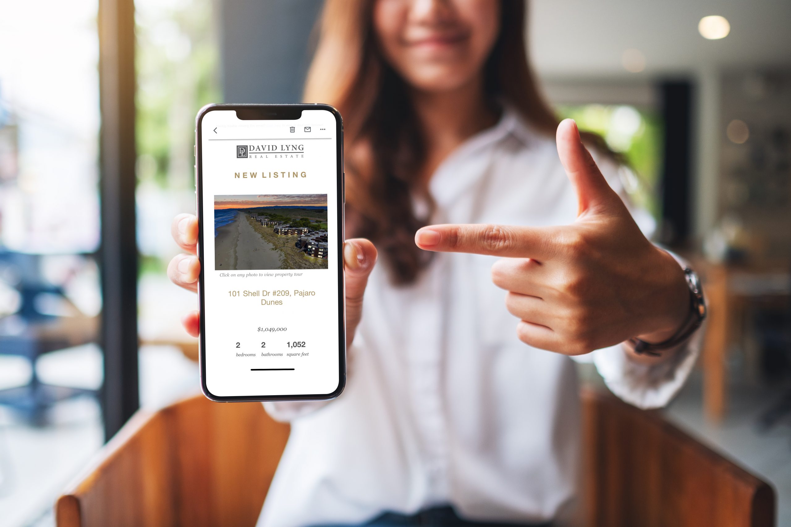 Mockup image of a beautiful woman pointing finger at a mobile phone with blank white screen